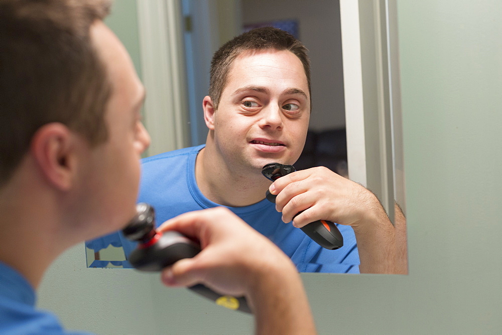 Man with Down Syndrome shaving in bathroom