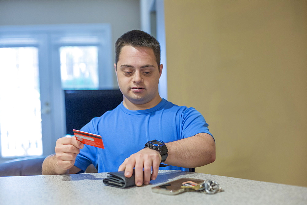 Man with Down Syndrome holding a credit card