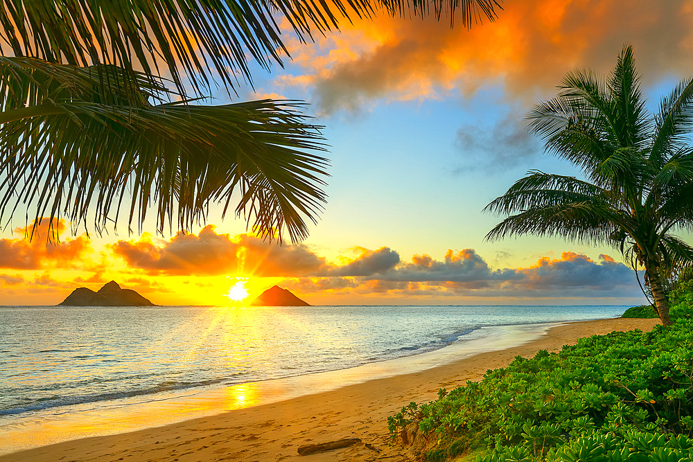 Sunrise viewed from Lanikai Beach with a view of the Mokulua Islands off the coast; Oahu, Hawaii, United States of America