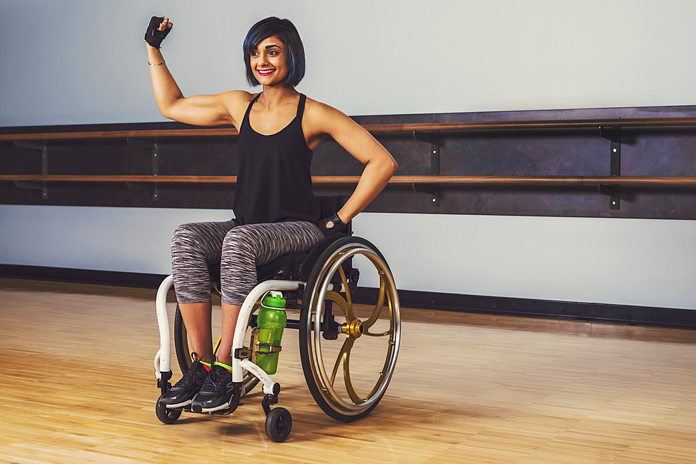 A paraplegic woman taking a break in a gymnasium after working out in a recreational facility: Sherwood Park, Alberta, Canada