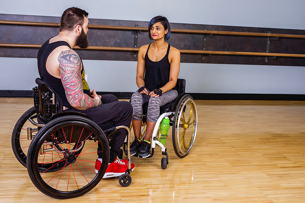 Two paraplegic friends talking together and encouraging each other after working out at a fitness facility: Sherwood Park, Alberta, Canada