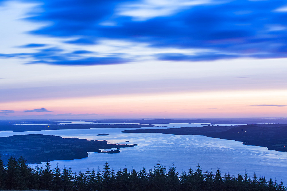 Dawn over Lough Derg with trees in the foreground, long exposure; County Clare, Ireland