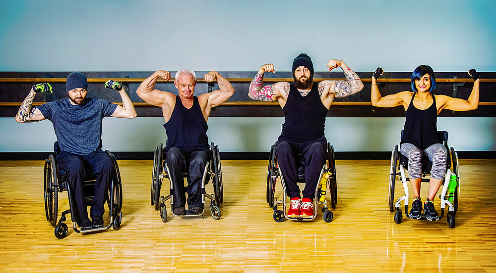 A group of paraplegic friends fooling around showing their muscles after a workout in fitness facility: Sherwood Park, Alberta, Canada