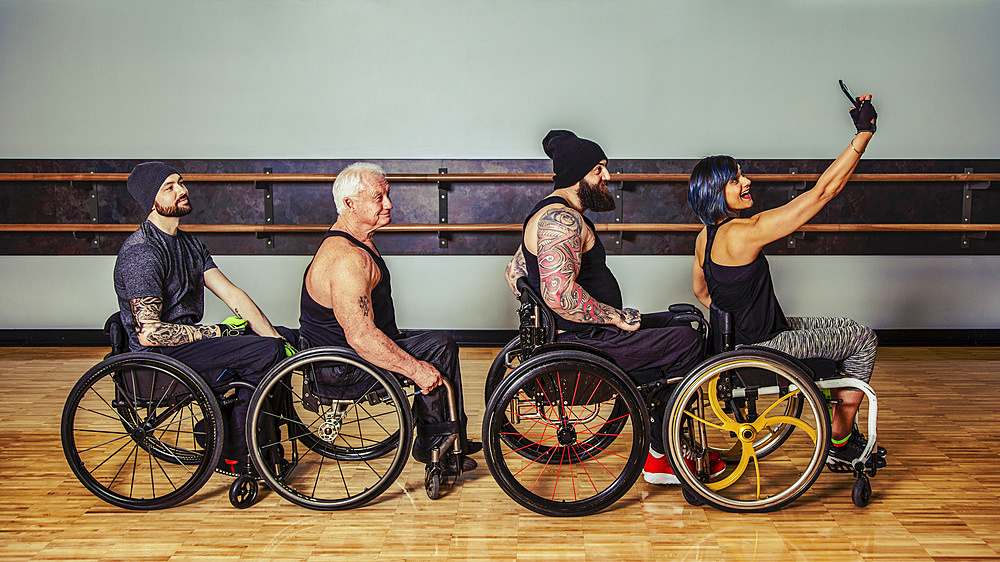 A group of paraplegic friends fooling around after a workout in fitness facility and taking a self-portrait of their wheelchair train: Sherwood Park, Alberta, Canada