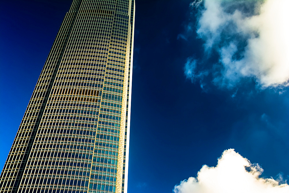 Architectural detail of a skyscraper with blue sky and white clouds; Hong Kong, Hong Kong Special Administrative Region (SAR), Hong Kong