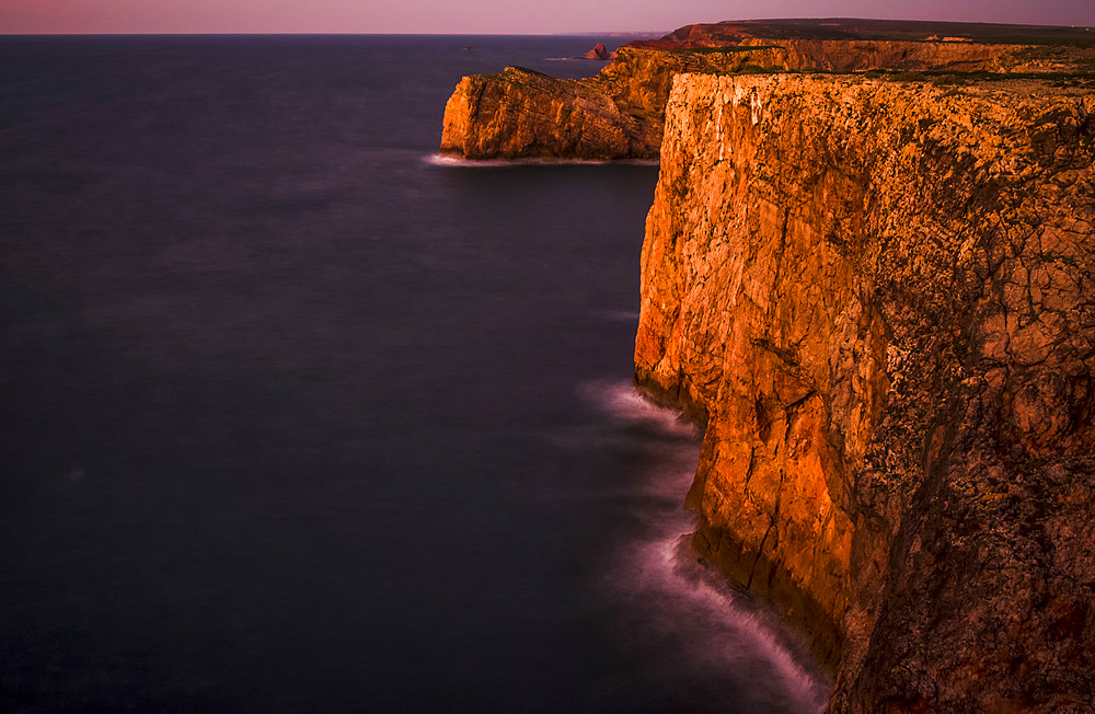 Long exposure of Portuguese cliffs at dusk at the most southwestern tip of Europe, Cape St. Vincent; Sagres, Algarve, Portugal