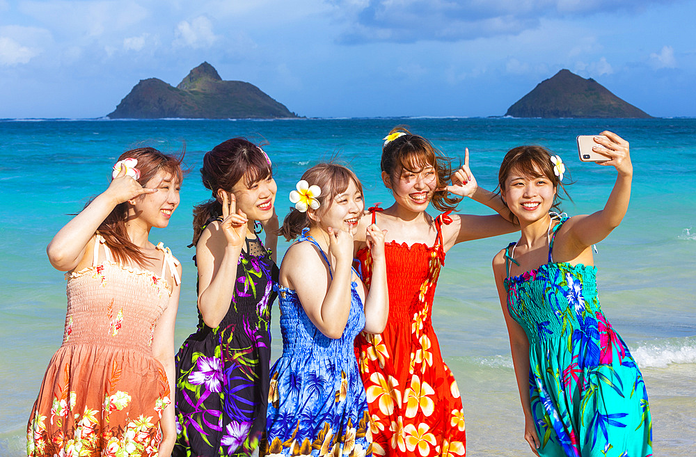 A group of Japanese students on vacation at Lanakai Beach with the Mokes Islands in the background: Oahu, Hawaii, United States of America