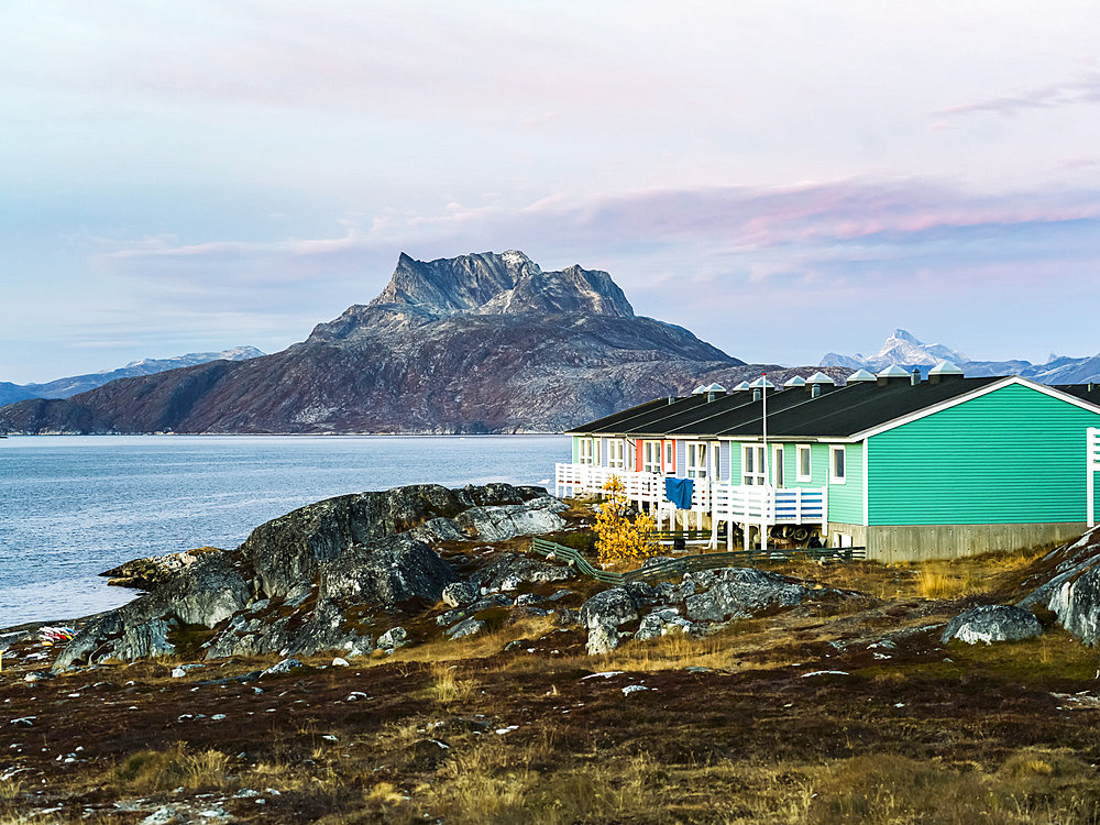 Colourful houses with decks on the back and mountains long the coastline; Nuuk, Sermersooq, Greenland