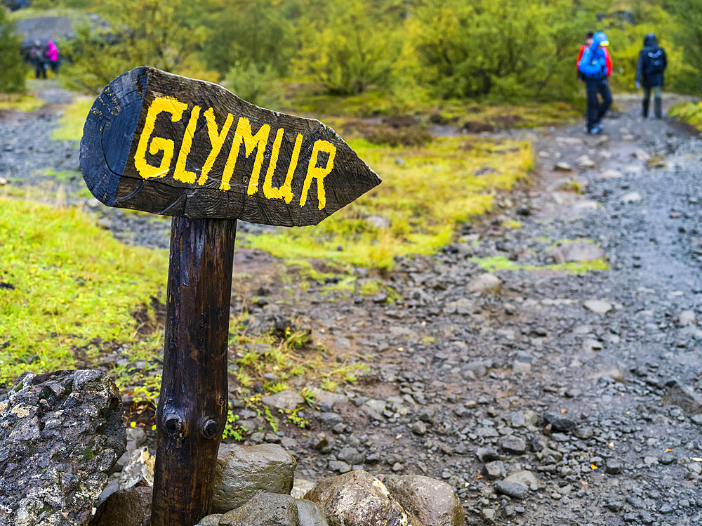 Tourists walking at the Glymur hiking trail. Glymur is the second-highest waterfall in Iceland, with a cascade of 198 metres; Hvalfjardarsveit, Capital Region, Iceland