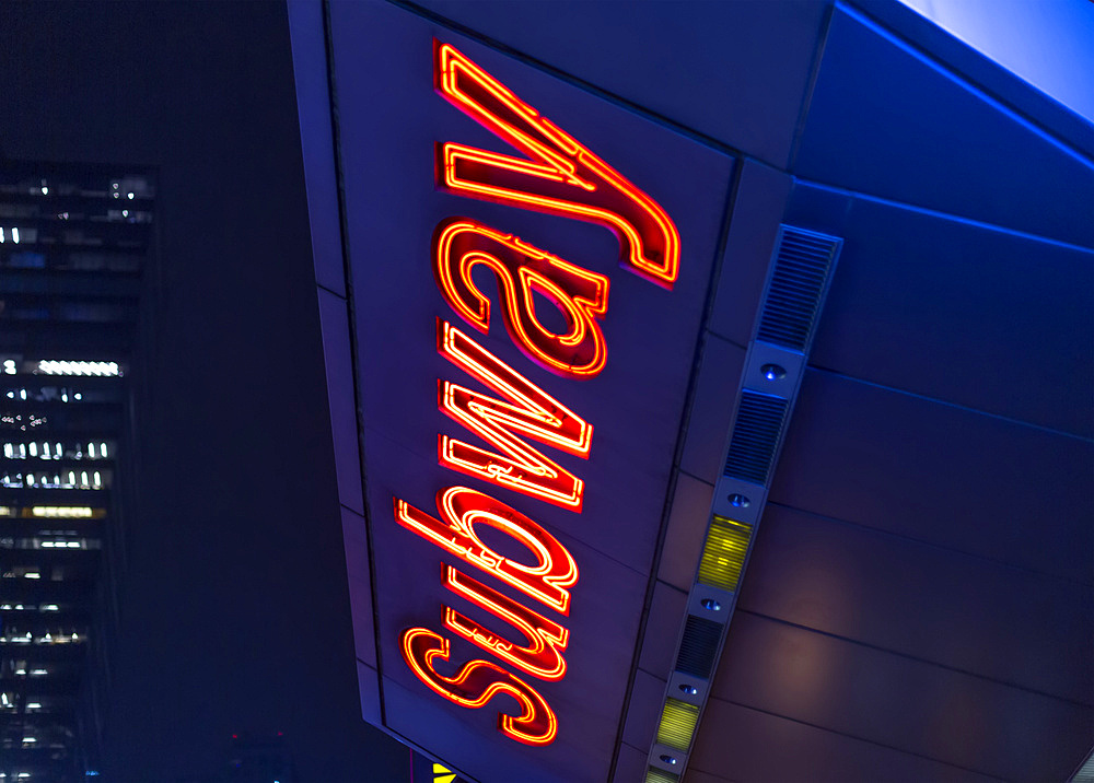 Subway sign illuminated at night in Manhattan; New York City, New York, United States of America