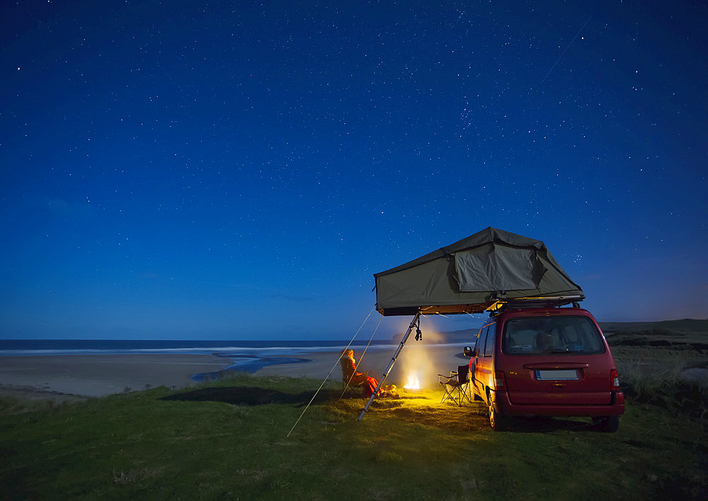 Car with roof tent camping by Falcarragh Beach at night; County Donegal, Ireland