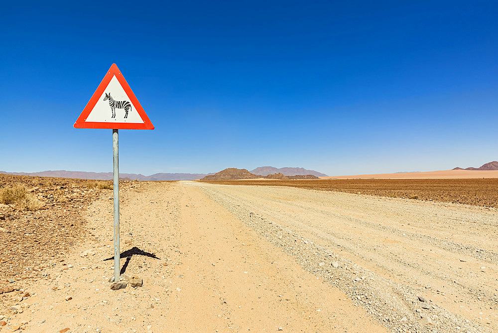 Attention wild animals sign on a long dry road, Namib Desert, Namib-Naukluft National Park; Namibia