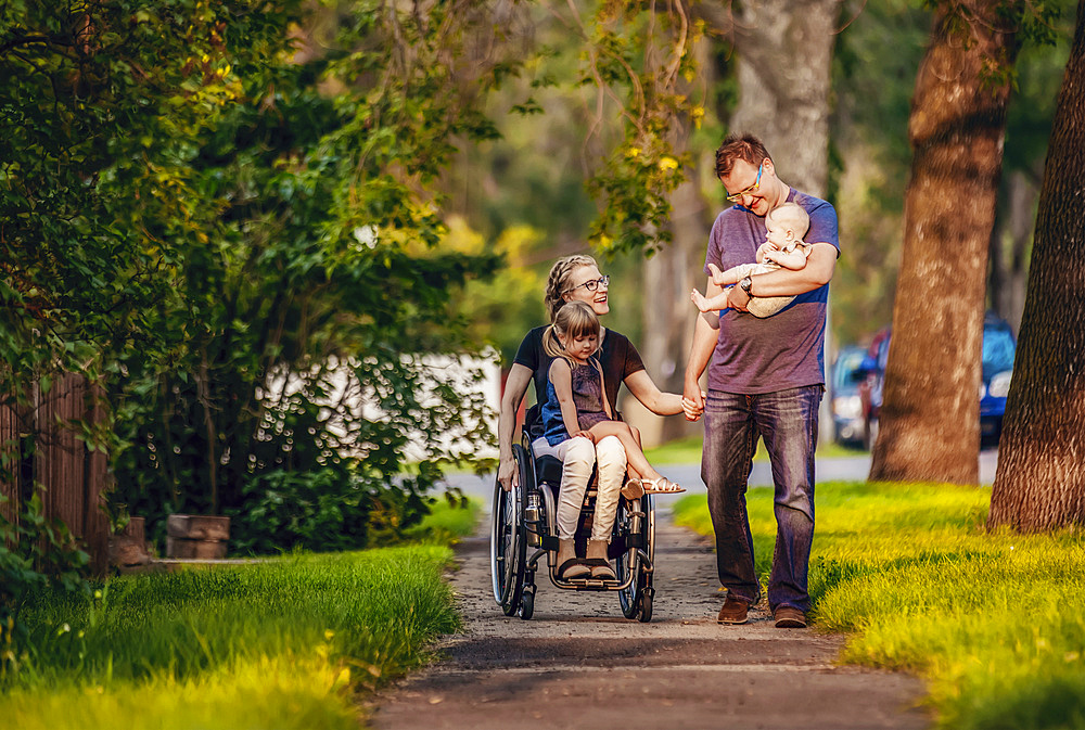 A family out walking in the evening and the mother is a paraplegic in a wheelchair; Edmonton, Alberta, Canada