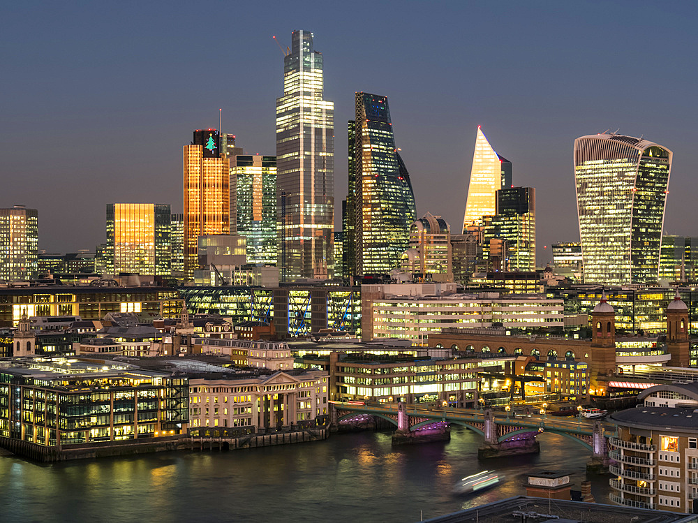 Cityscape and skyline of London at dusk with 20 Fenchurch, 22 Bishopsgate, and various other skyscrapers, and the River Thames in the foreground; London, England