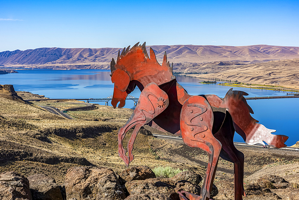 Metal art depicting wild horses running across a ridge atop the Wild Horse Monument near the town of Vantage in Eastern Washington. Wanapum Lake formed by a dam on the Columbia River and the I-90 Bridge in the background; Vantage, Washington, United States of America