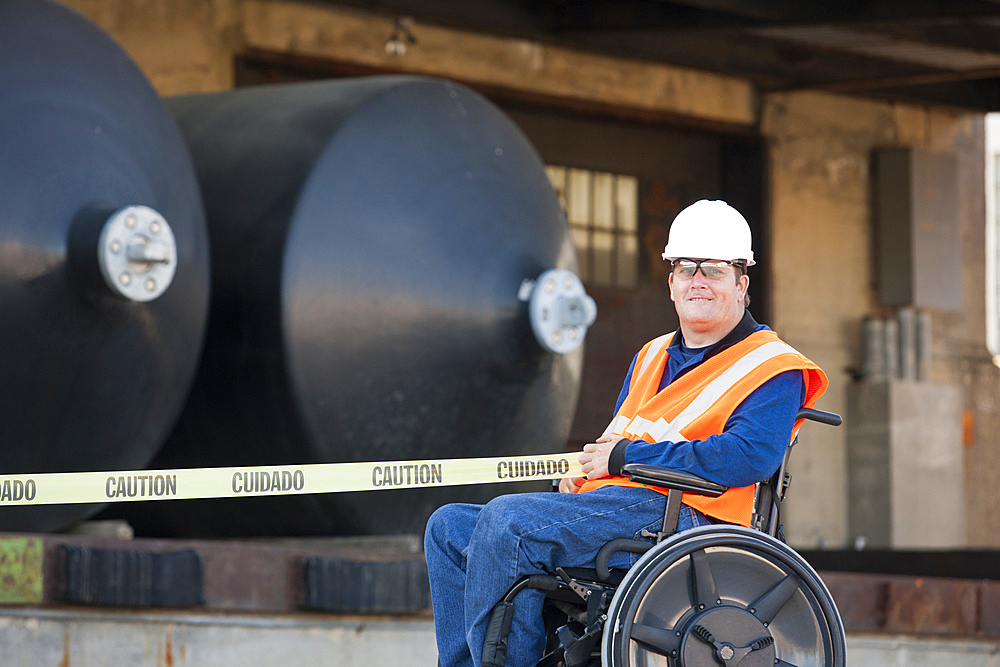 Man in wheelchair holding caution tape