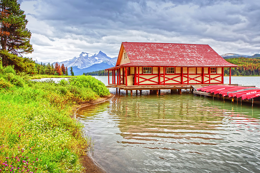 A building and canoes lined up on a dock on Maligne Lake in Jasper National Park in the Rocky Mountains; Alberta, Canada