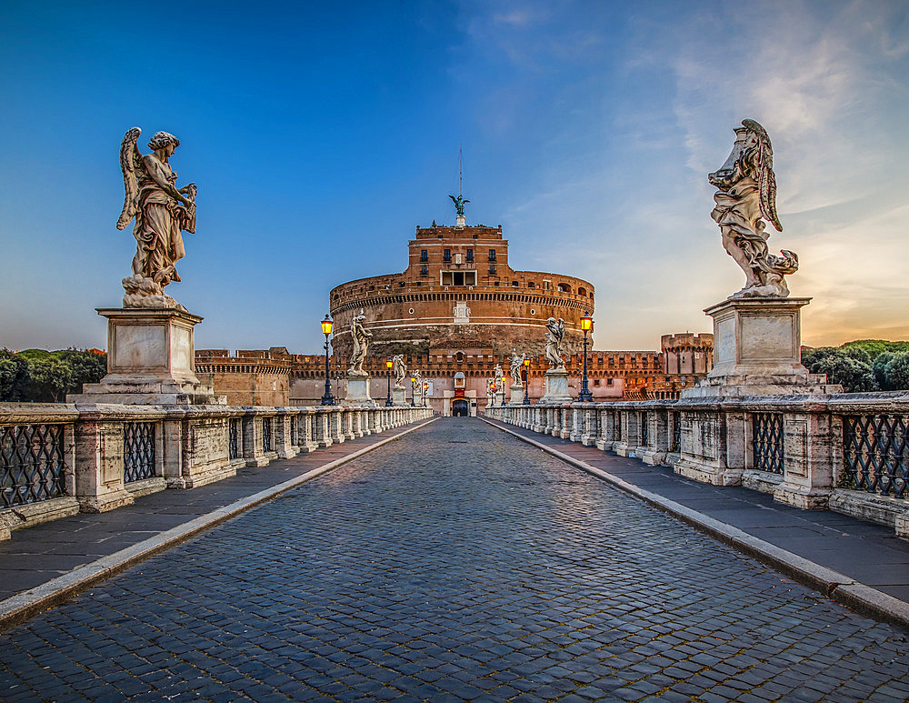 Ponte Sant'Angelo spanning the Tiber River and lined with statues of angels leading to the Castel Sant'Angelo (Mausoleum of Hadrian) at dusk; Rome, Lazio, Italy