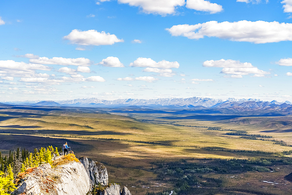 Woman hiking along the Dempster Highway enjoying the scenery on top of Sapper Hill; Yukon, Canada