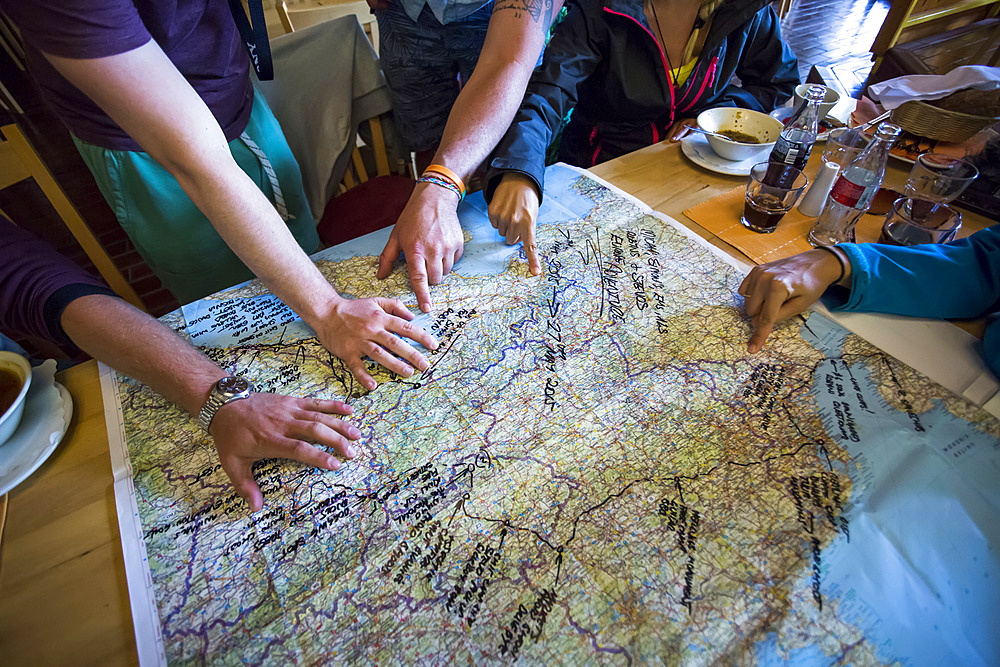 A group of travellers trace their trip on a map; Bled, Slovenia