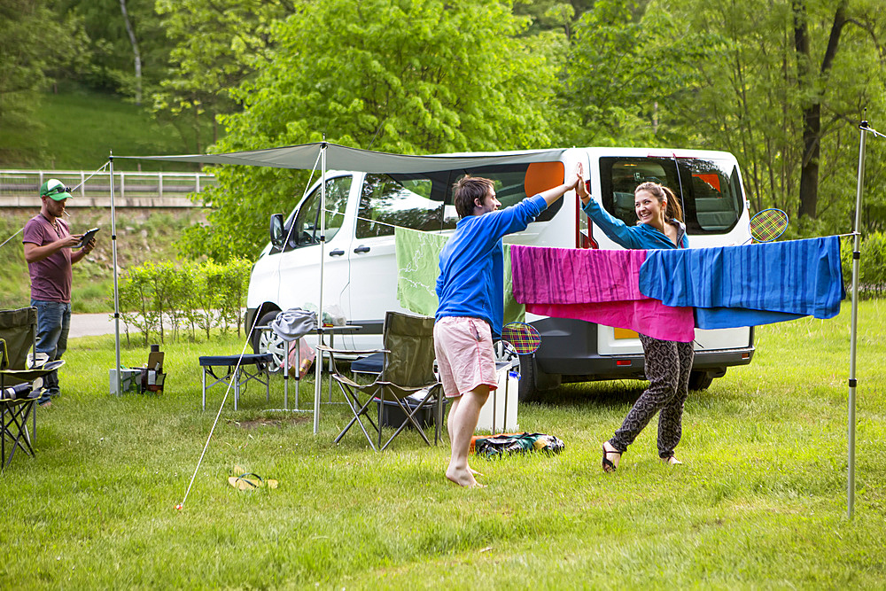 Campers playing badminton next to their camper van at a campsite just outside of the city center of a beautiful medieval city in South Bohemian Region; Cesky Krumlov, Bohemia, Czech Republic