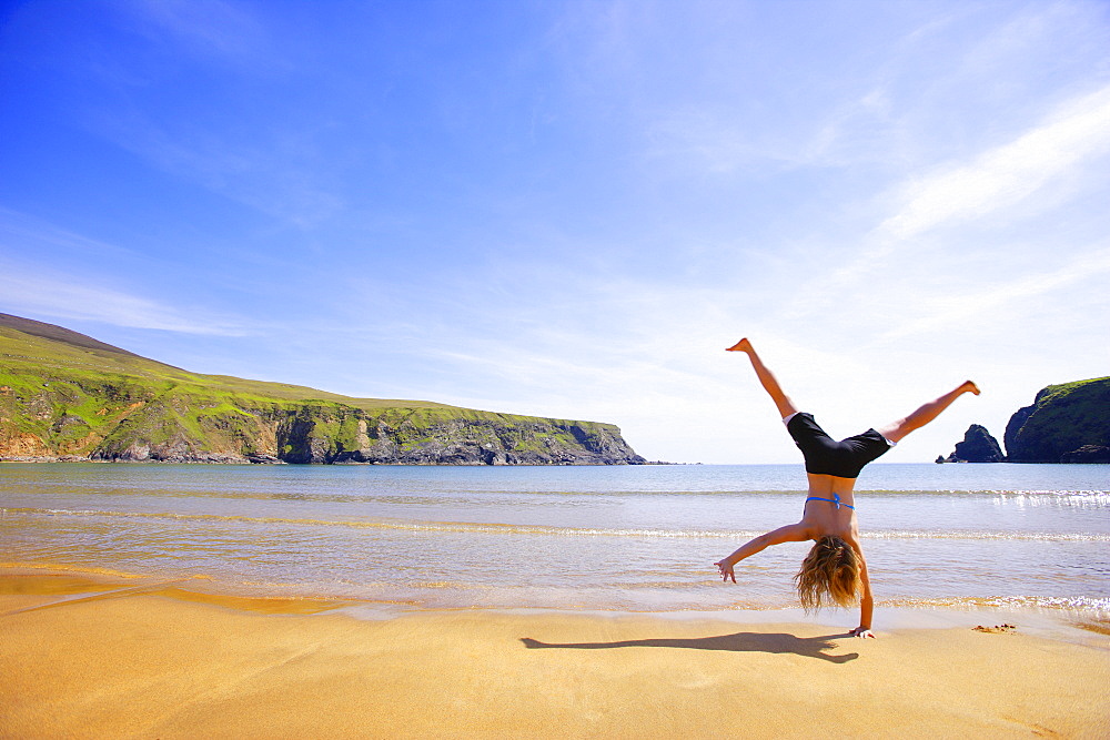 Woman Performing A Cartwheel On A Beach, Ireland