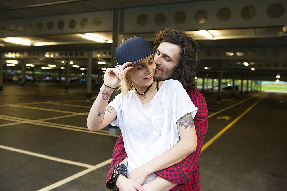 A cool young couple cuddling.