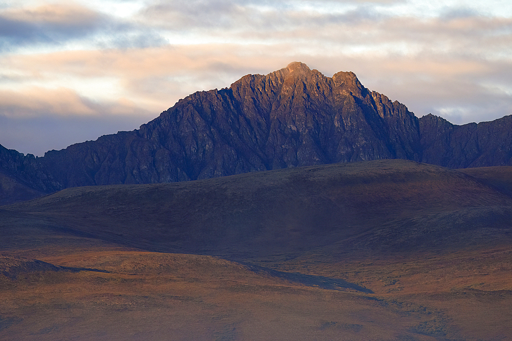 Autumn creeps in slowly after a warm Yukon summer. The mountains are lit up with storm light creating dynamic scenery, Yukon, Canada