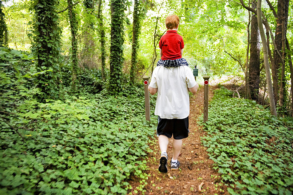 Father and son enjoy a walk through a wooded area, Marietta, Georgia, United States of America