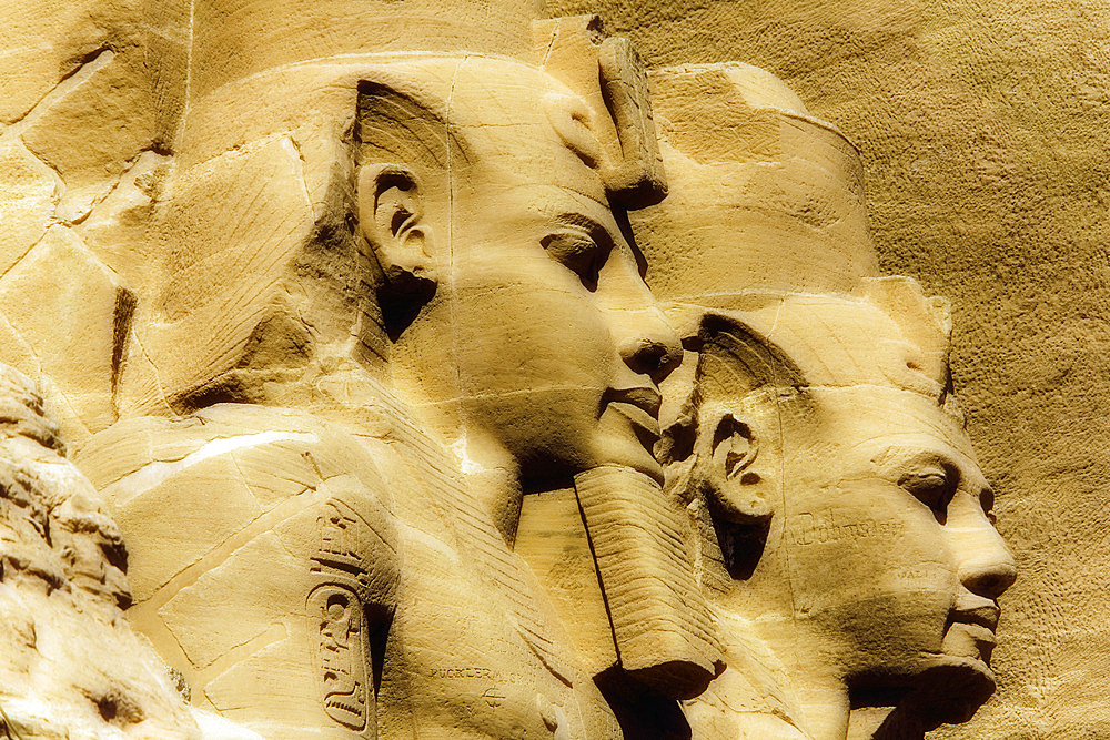 Close-up of two of the Ramses II statues carved out of the mountainside at the front of the Great Sun Temple of Abu Simbel, Abu Simbel, Nubia, Egypt