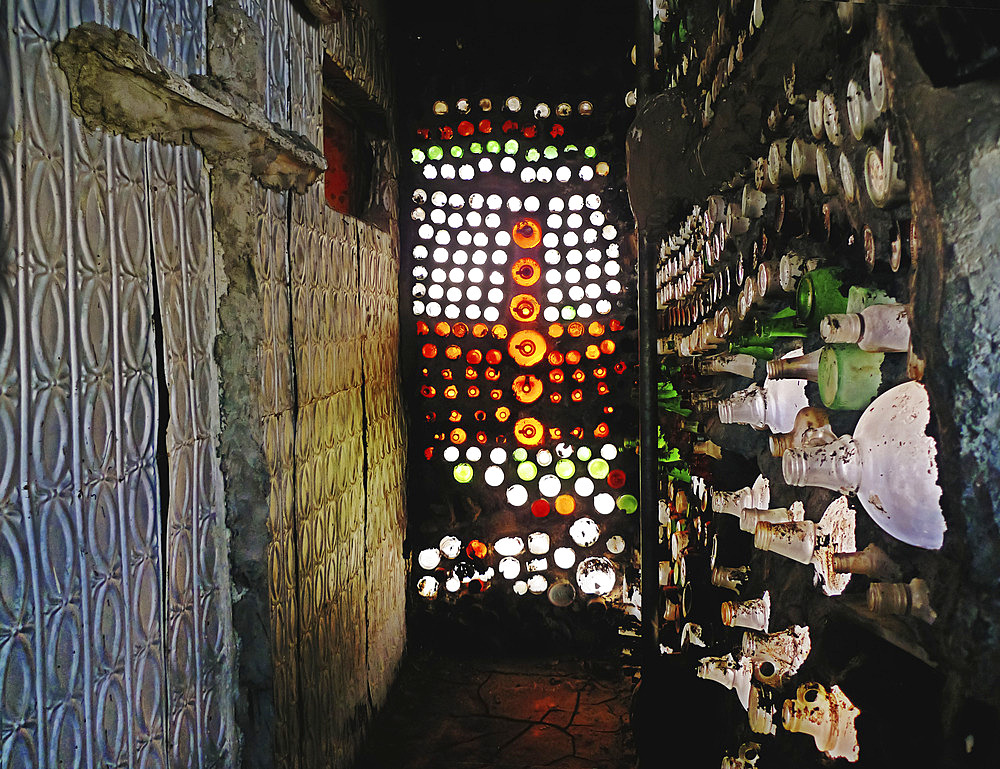 Colorful glass bottles, and embossed, metal ceiling tiles are repurposed features of an architectural folly, Imlay, Nevada, United States of America