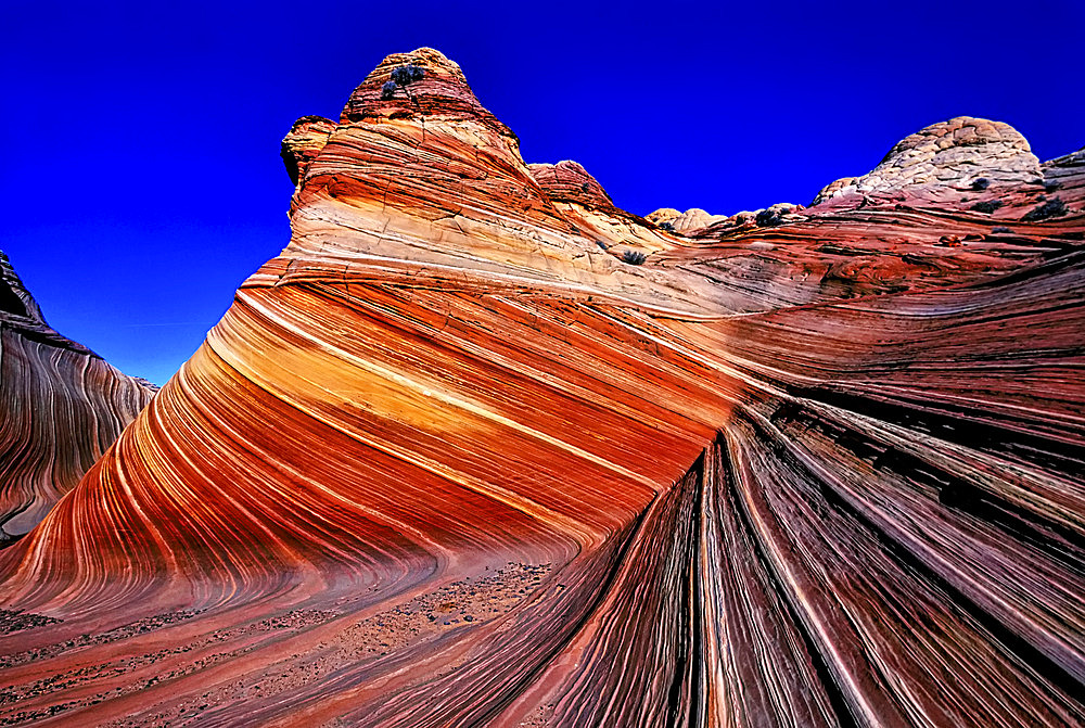 Spectacular formation of vibrant colors in swirls of fragile sandstone is known as The Wave and is located in the Coyote Buttes section of Vermilion Cliffs National Monument. An unmarked wilderness trail limits hikers and requires a permit from the Bureau of Land Management, Arizona, United States of America