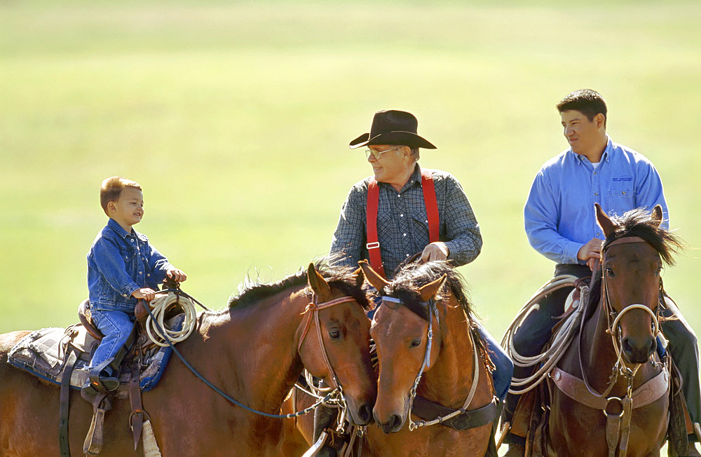 Rancher, his son and grandson on horseback, Howes, South Dakota, United States of America