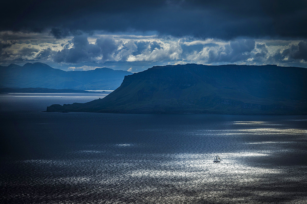 Small yacht sailing past Eigg Island in the Scottish Inner Hebrides, Scotland