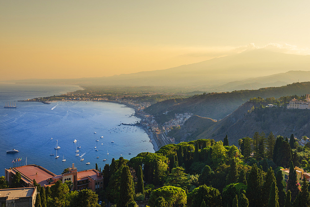 View of the town of Taormina, Sicily, Italy and the coastline at sunset, Taormina, Sicily, Italy