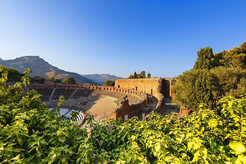 Tourists at the ruins of an ancient Greek theatre in the town of Taormina, Sicily, Italy, Taormina, Sicily, Italy