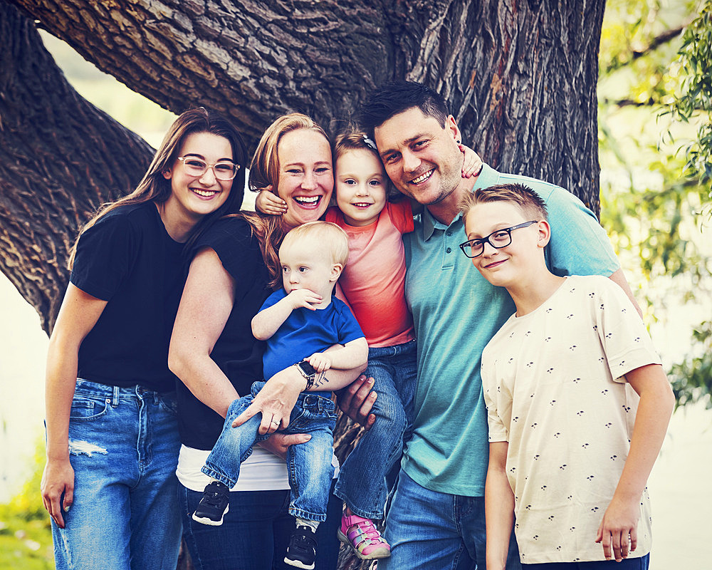 Outdoor family portrait in a city park on a warm fall afternoon and the youngest son has Down syndrome, Leduc, Alberta, Canada