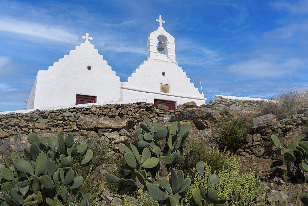 Whitewash church with bell and cross on a steeple against a blue sky, on the island of Mykonos, Greece, Mykonos, South Aegean, Greece