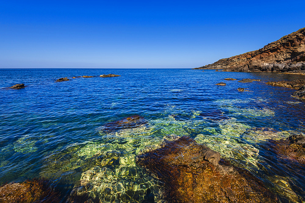 Coastal view of the Mediterranean Sea and rocky shore along the rugged cliffs of Pantelleria Island, Sicily, Italy