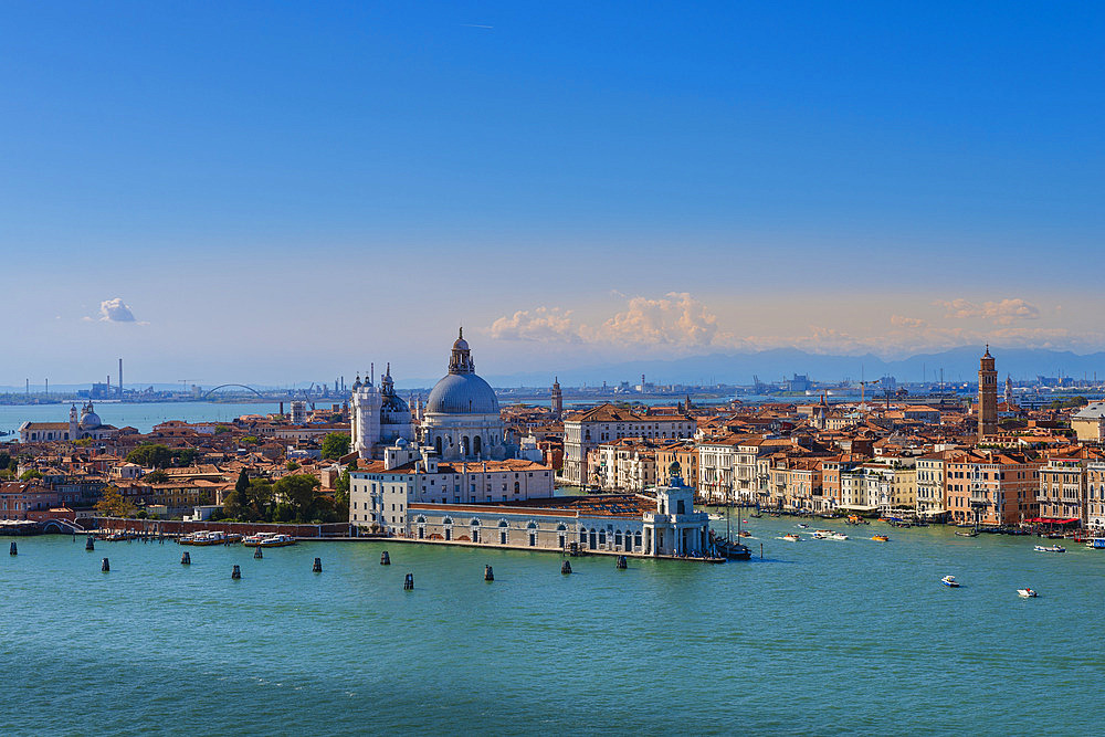 View from the Church of San Giorgio Maggiore of the City of Venice with Chiesa Santa Maria della Salute at Punta della Dogana and boats traveling through the Grand Canal on a sunny day, Venice, Veneto, Italy