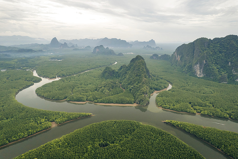 Expanse of lush vegetation, tranquil waterways and rock formations under a cloudy sky viewed from the drone in Thailand, Ao Phang Nga, Phang-nga, Thailand