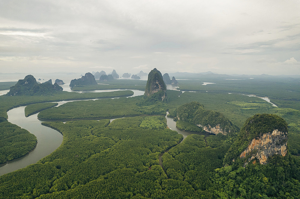 Expanse of lush vegetation, tranquil waterways and rock formations under a cloudy sky viewed from the drone in Thailand, Ao Phang Nga, Phang-nga, Thailand