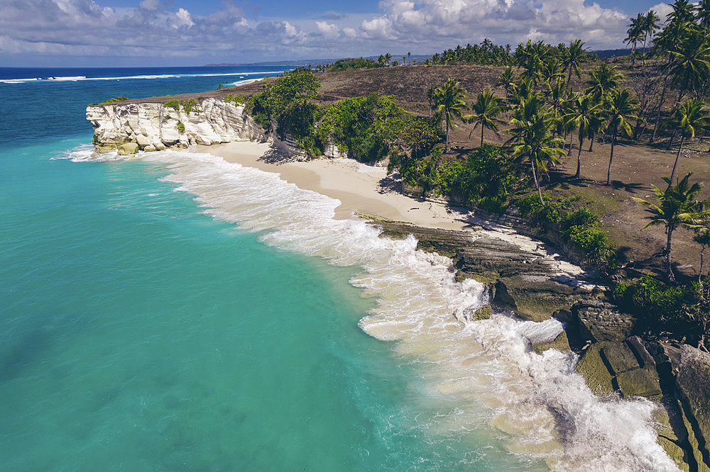 Beautiful tropical coastline of Mbawana Beach with the surf rolling into the white sand beach with palm trees, East Nusa Tenggara, Indonesia, Kodi Bangedo, Southwest Sumba Regency, East Nusa Tenggara, Indonesia