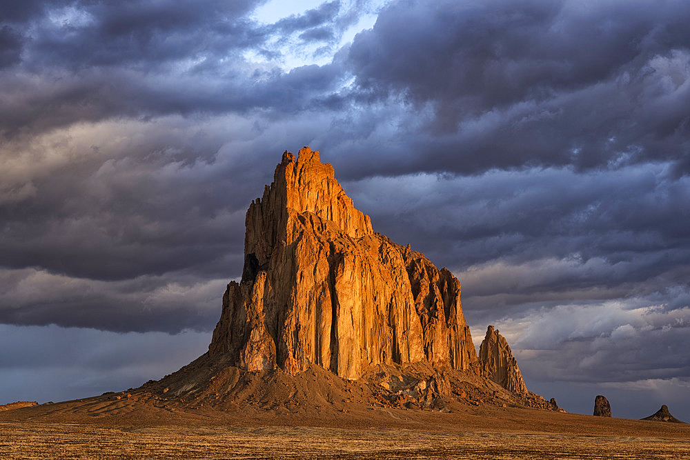 Storm clouds gather over Shiprock, New Mexico. The rising suns illuminates this sacred rock of Navajo people, Shiprock, New Mexico, United States of America