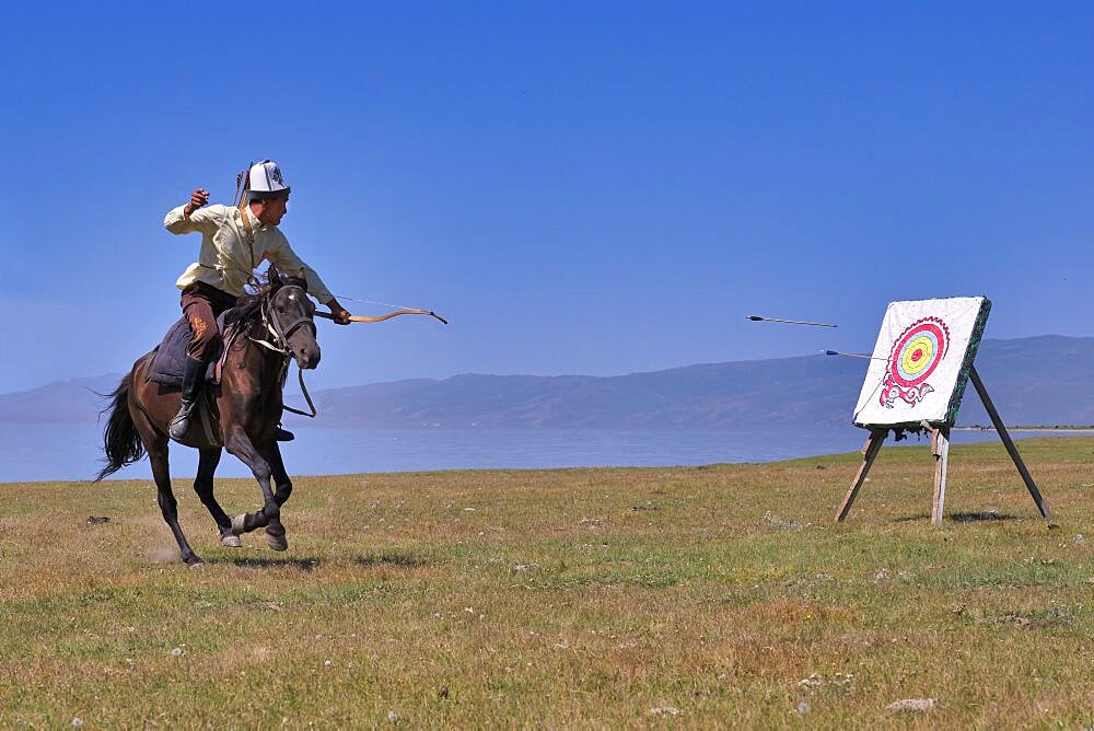 Kyrgyz nomad shooting arrows on a target while galloping, Song kol lake, Naryn region, Kyrgyzstan