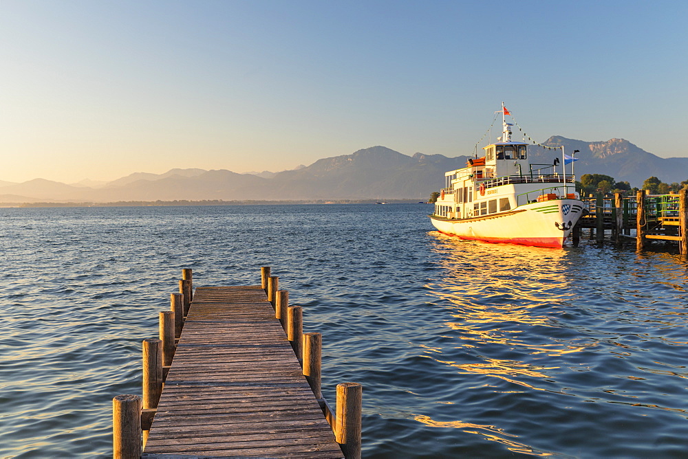 Excursion boat on a jetty at sunrise, Gstadt am Chiemsee, Lake Chiemsee, Upper Bavaria, Germany, Europe