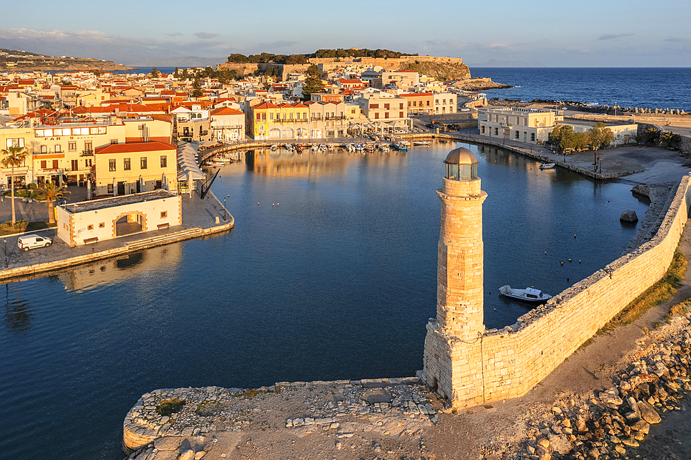 Lighthouse at the Venetian harbor with a view of Venetian Fortezza, Rethymno, Crete, Greek Islands, Greece, Europe