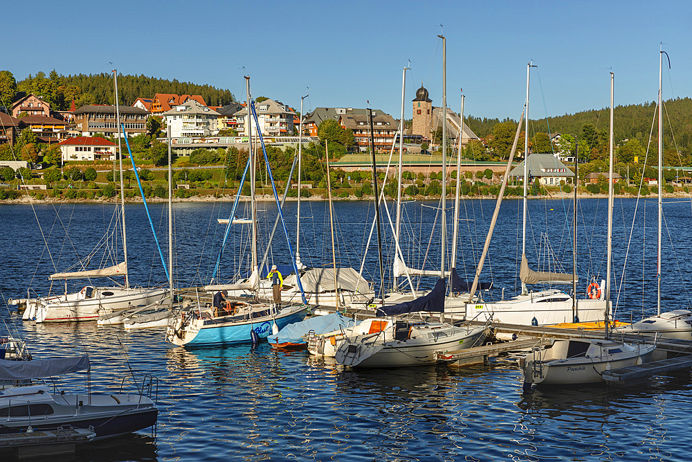 Boat dock with boats moored on water with view over Schluchsee, Schwarzwald (Black Forest), Baden-Wurttemberg, Germany, Europe