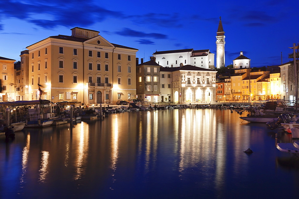 Waterfront buildings at the harbour and bell tower of Cathedral of St. George, Piran, Istria, Slovenia, Europe