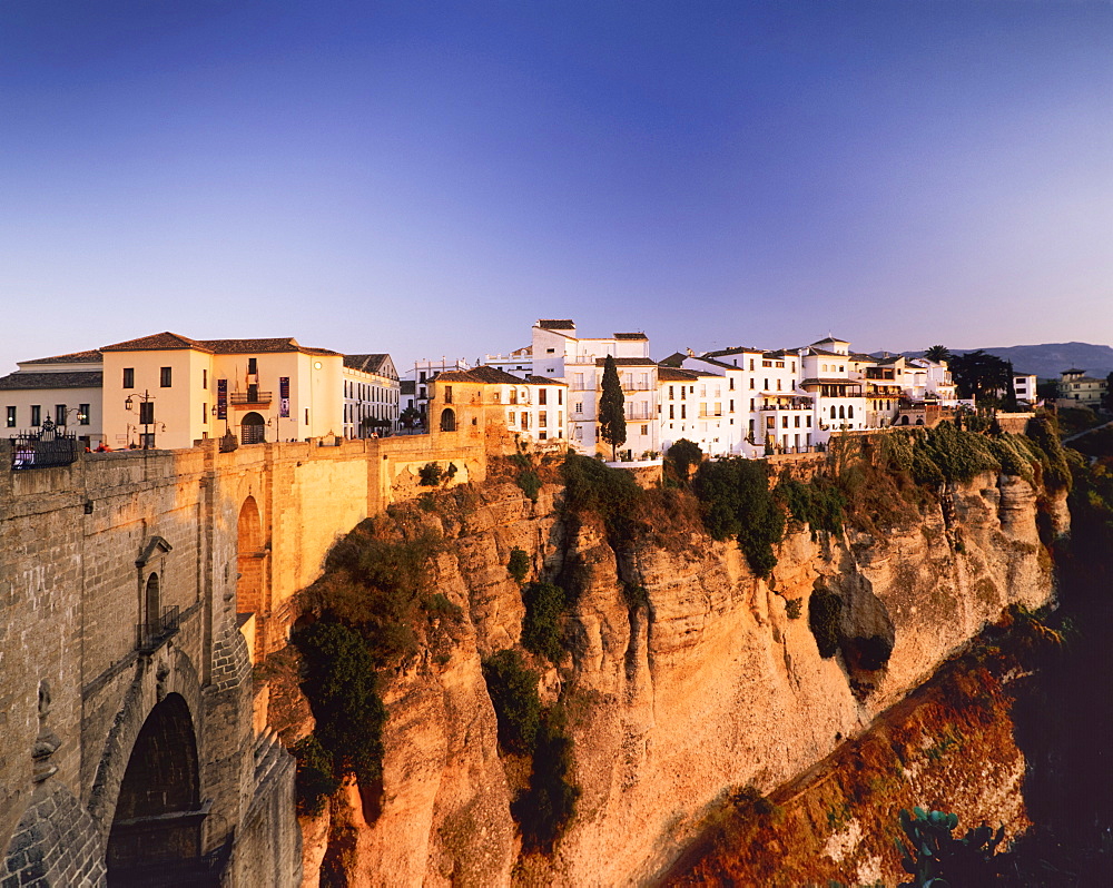 Houses on the Tajo edge and the bridge Puente Nuevo, old town of Ronda at sunset, Province Malaga, Andalusia, Spain, Europe 